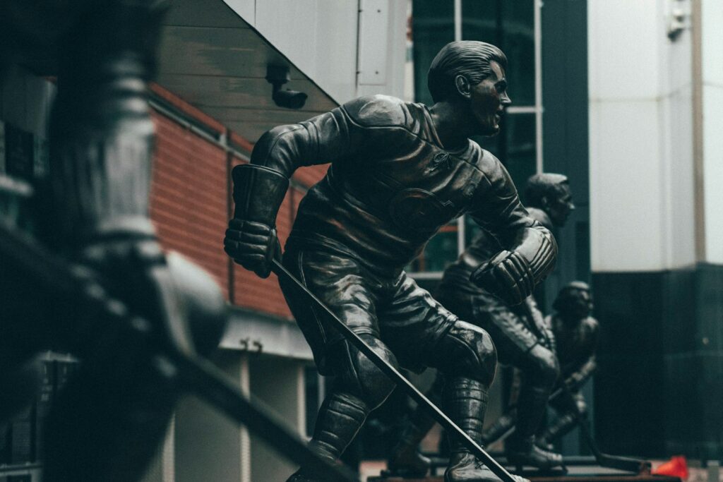 selective focus photography of ice hockey player statues
